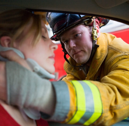 Firefighters helping an injured woman in a car